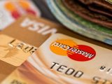 Forskellige kreditkort ligger på bord med penge